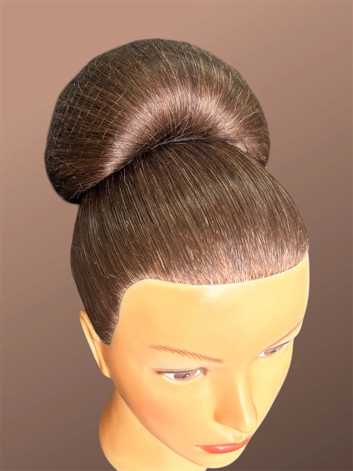A smooth, precisely constructed high bun on a hair training mannequin.