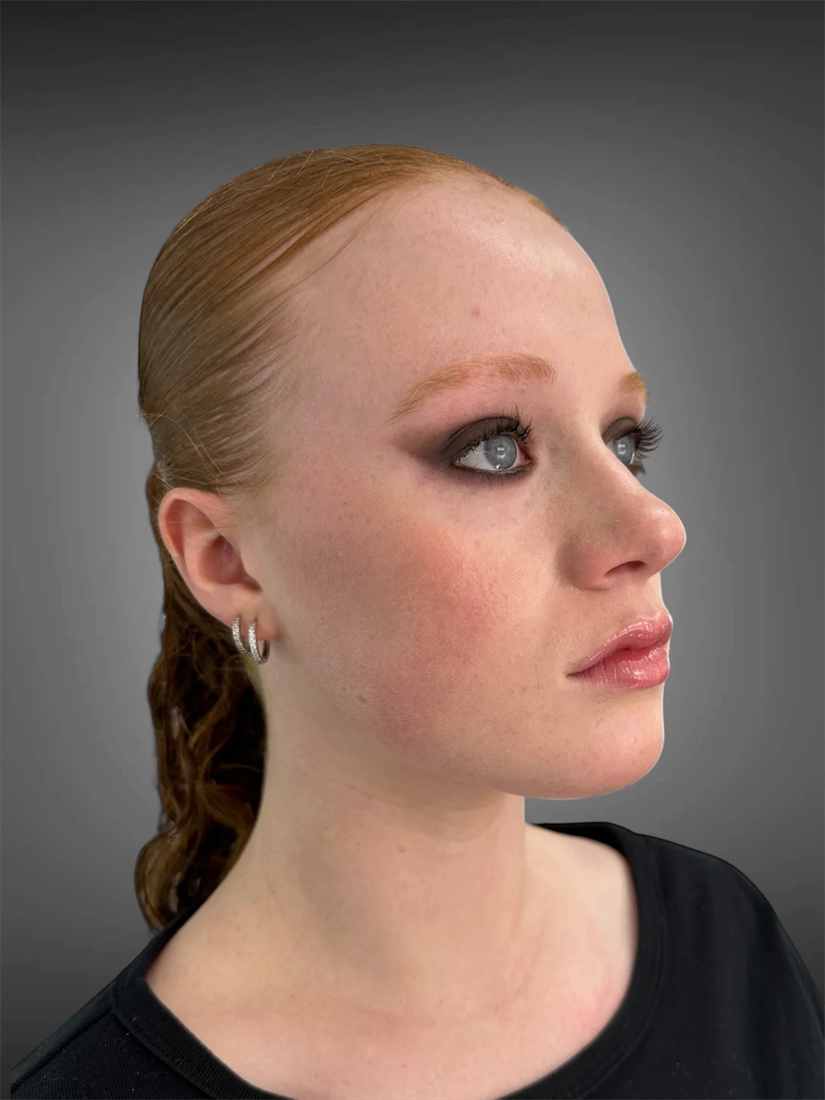 Sculpted smoky eye makeup and softly finished skin, photographed in profile.
